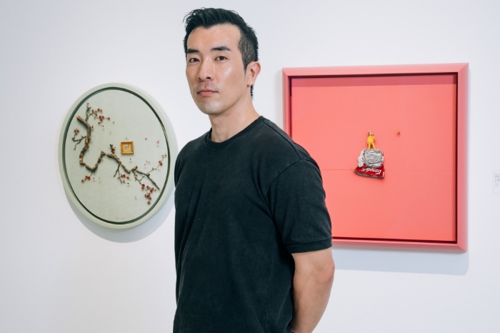 Kim JunSik in front of his paintings Image