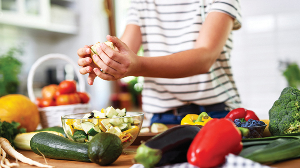 Midsection Of Teenage Girl Preparing Food In Kitchen At Home